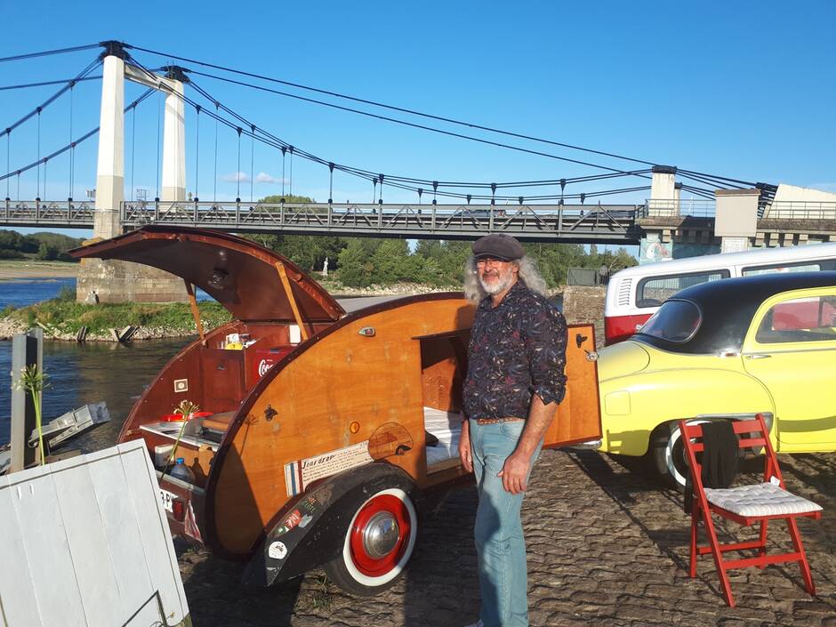 Pierric Communal devant sa caravane Teardrop et sa Renault Frégate à la fête du Chanvre